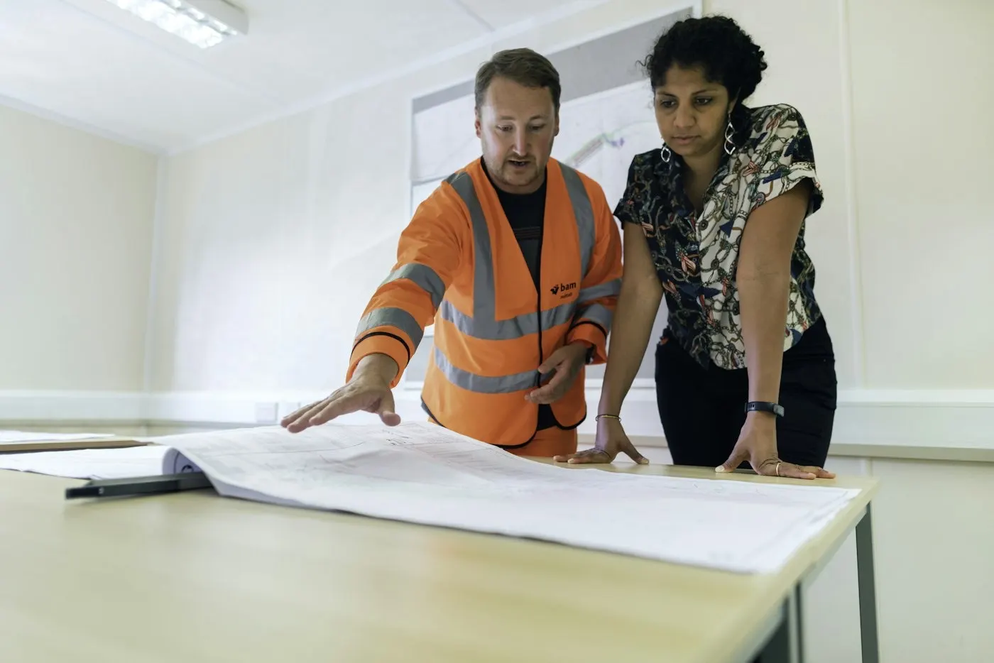 Ingénieurs en usine autour de plans, IA industrielle